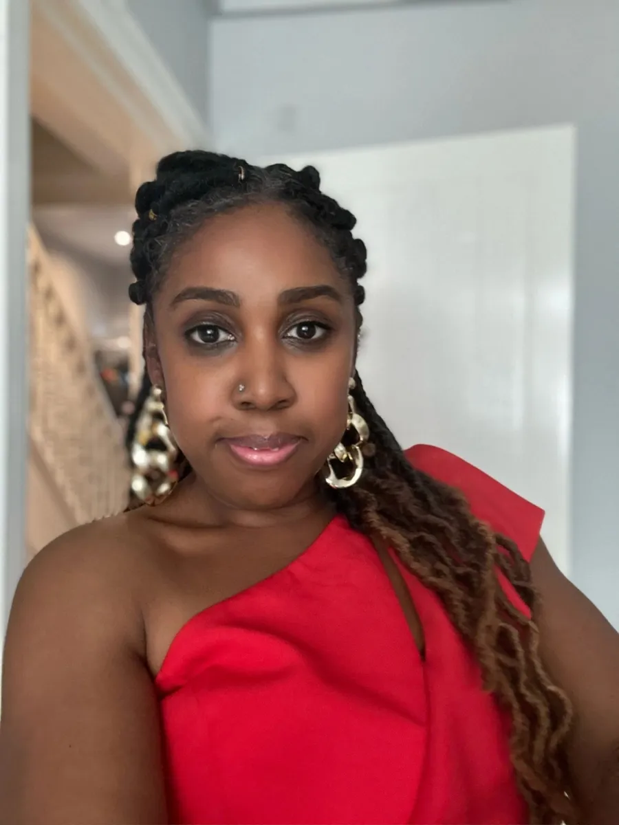 Roianne Nedd in a red dress, smiling